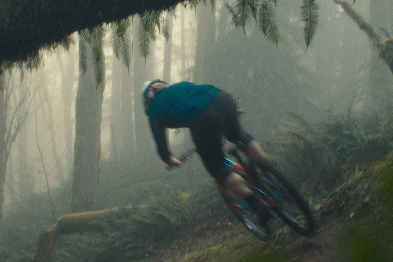 Mann fährt auf einem Mountain-Bike den Berg runter.