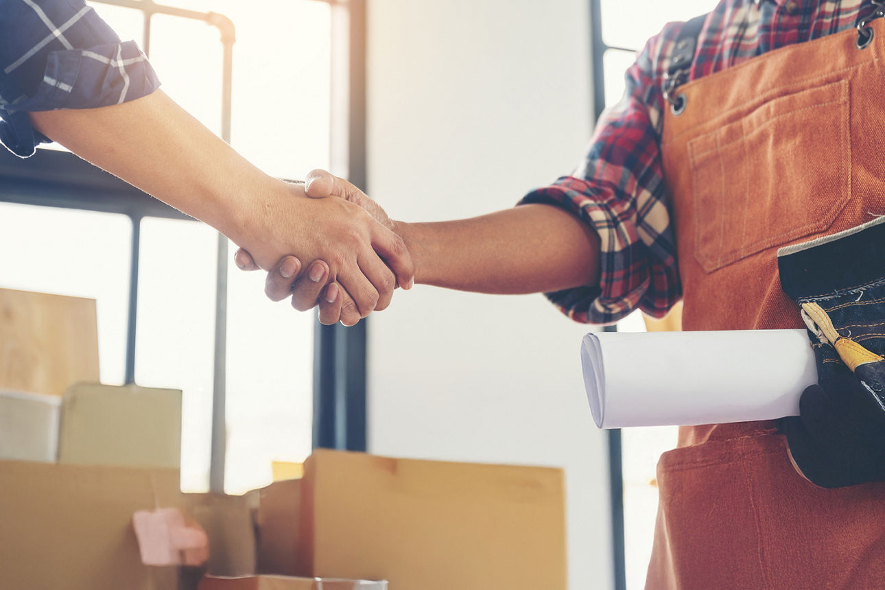 Zwei Hände schüttelnde Männer in einem Büro