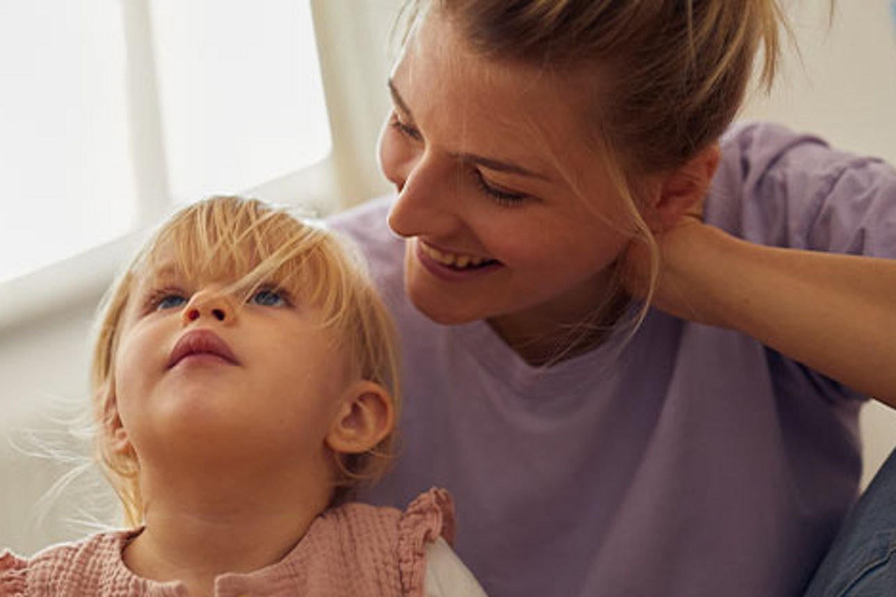 Kleines Mädchen auf dem Schoß seiner Mutter