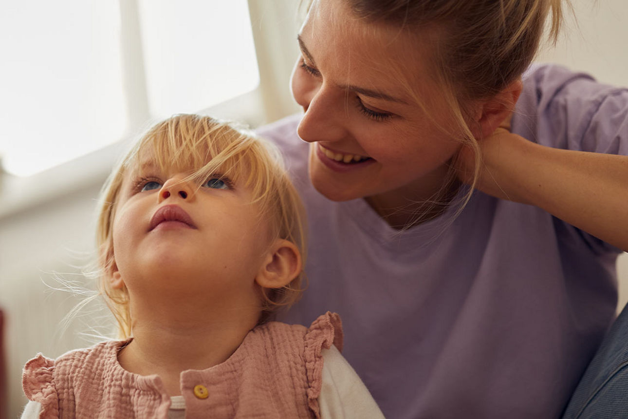 Kleines Mädchen auf dem Schoß seiner Mutter